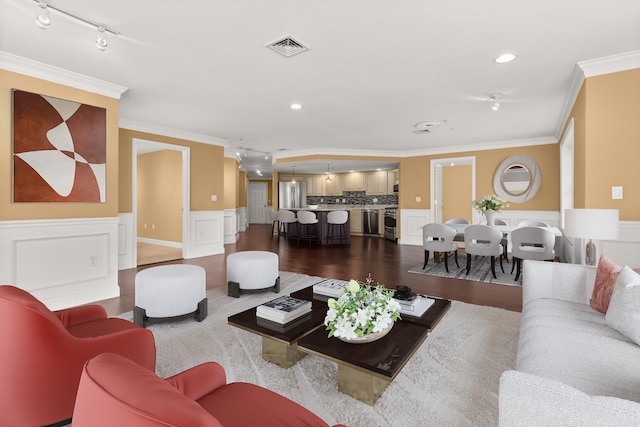 living room with hardwood / wood-style flooring, track lighting, and ornamental molding