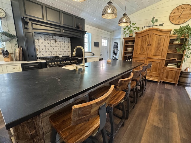 kitchen featuring wood ceiling, stove, sink, dark hardwood / wood-style flooring, and vaulted ceiling