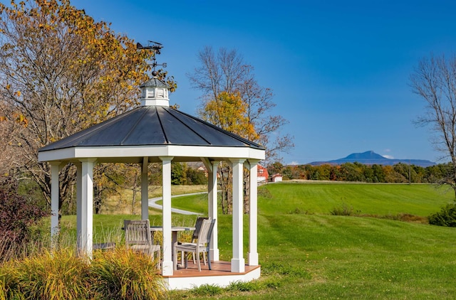 view of community with a gazebo, a mountain view, and a lawn