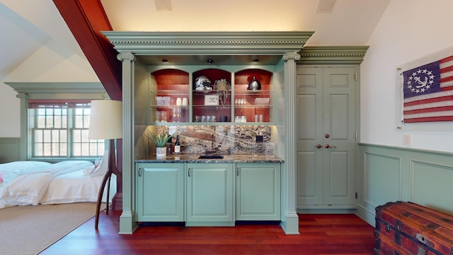 bar featuring vaulted ceiling, dark wood-type flooring, and dark stone countertops