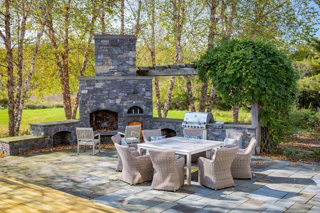 view of patio featuring an outdoor kitchen, a grill, and an outdoor stone fireplace