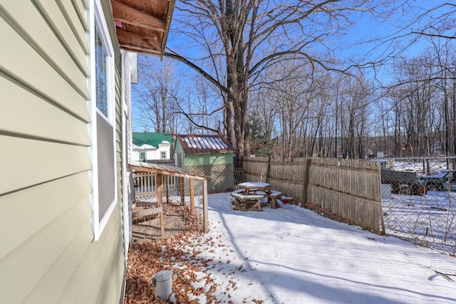 yard layered in snow with a shed