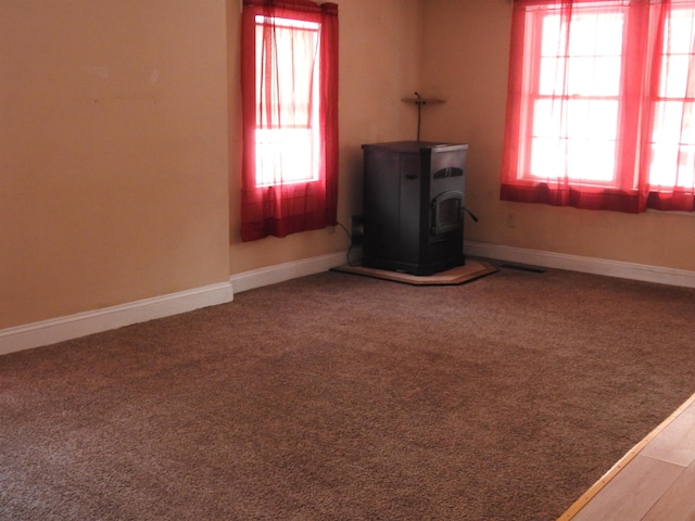 carpeted empty room with a wood stove