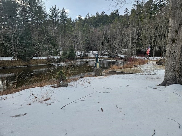 snowy yard featuring a water view