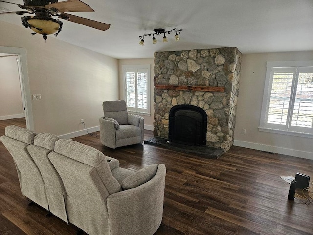 living room featuring ceiling fan, rail lighting, dark hardwood / wood-style flooring, and a fireplace