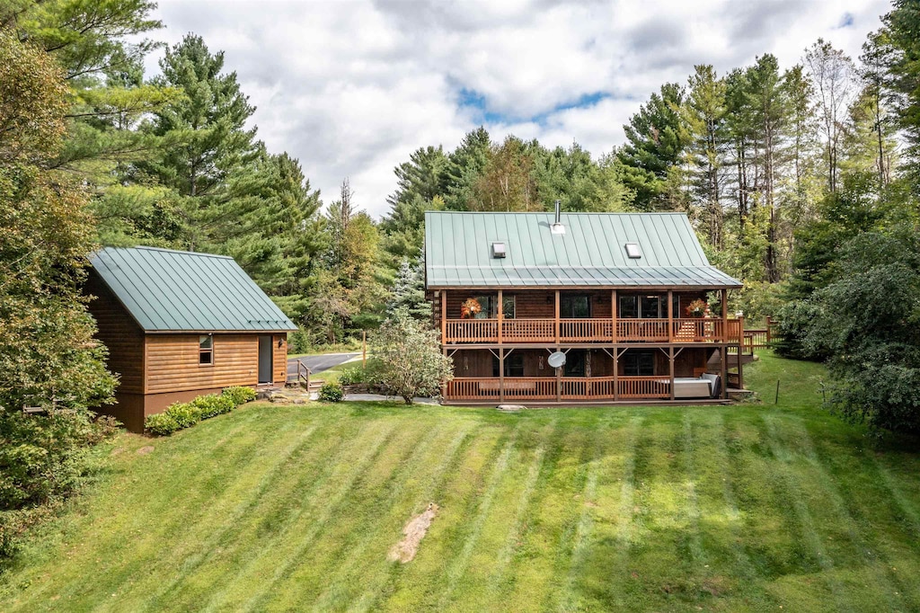 back of house featuring a lawn and a wooden deck