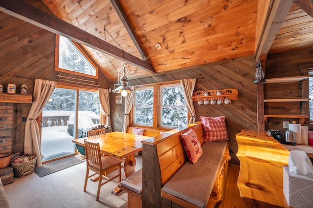 dining space featuring beamed ceiling, wooden ceiling, wooden walls, light carpet, and high vaulted ceiling