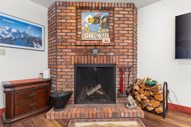 living room with hardwood / wood-style flooring and a brick fireplace