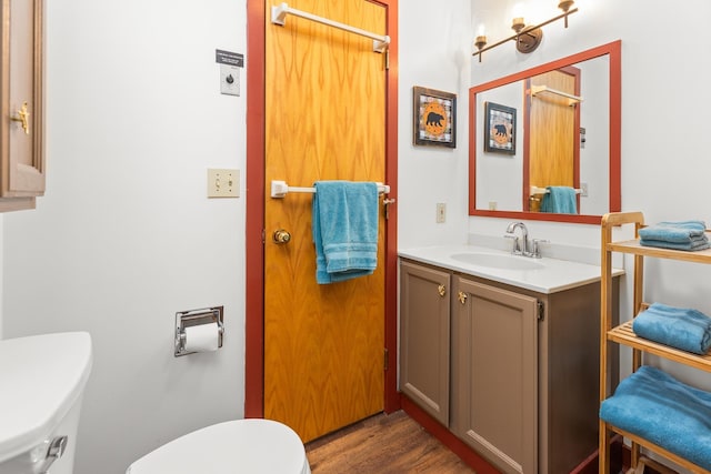 bathroom with vanity, hardwood / wood-style floors, and toilet