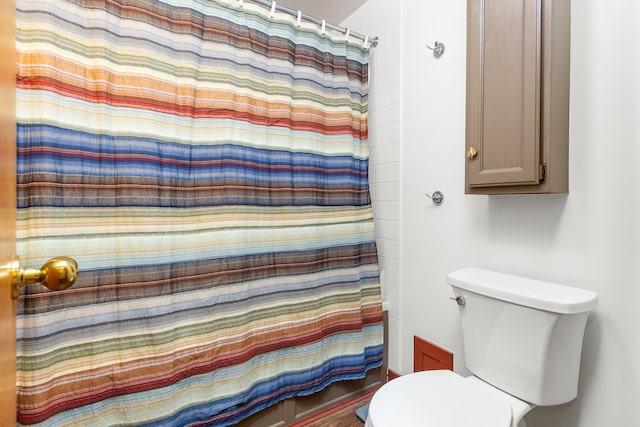 bathroom with toilet and a shower with shower curtain