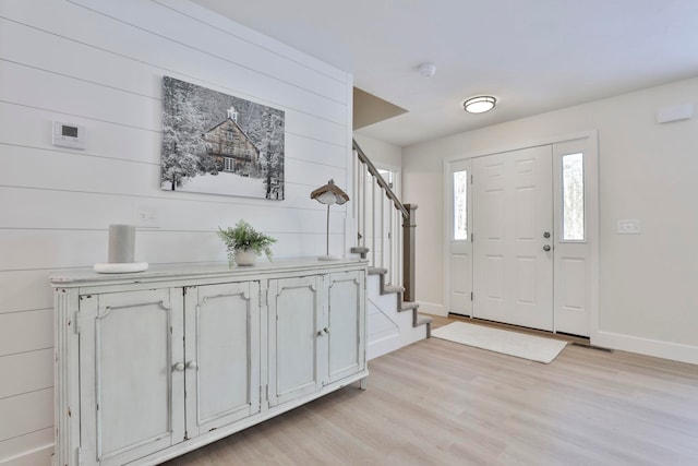 foyer featuring wooden walls and light hardwood / wood-style floors