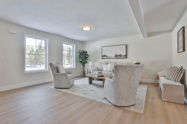 living room with beamed ceiling and light hardwood / wood-style floors