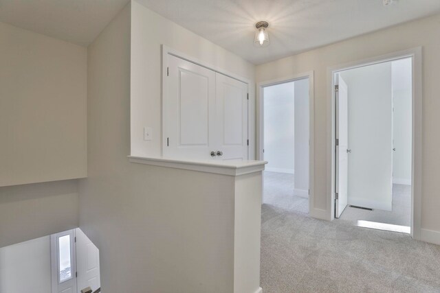 hallway with light colored carpet