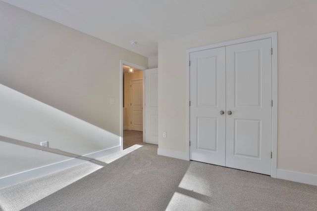 unfurnished bedroom featuring carpet floors and a closet