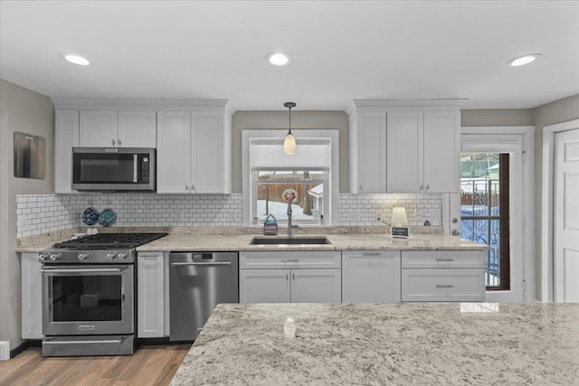 kitchen with appliances with stainless steel finishes, sink, and white cabinets