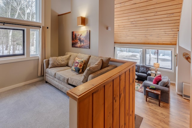 living room featuring light hardwood / wood-style floors, a towering ceiling, and a wealth of natural light