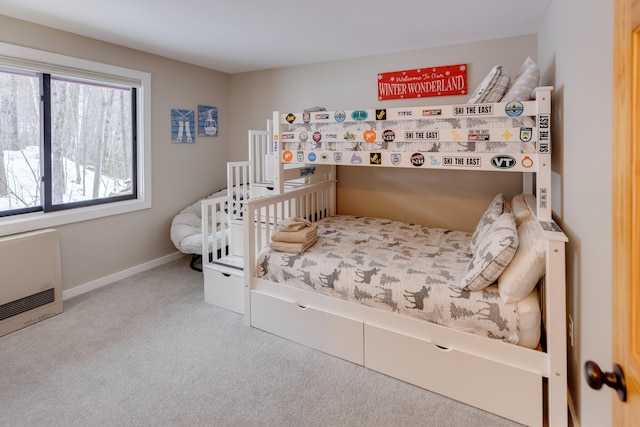 bedroom with heating unit and light colored carpet