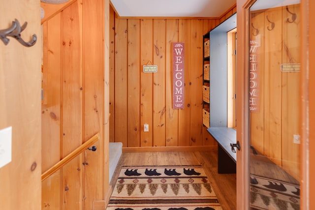 mudroom featuring hardwood / wood-style flooring and wooden walls