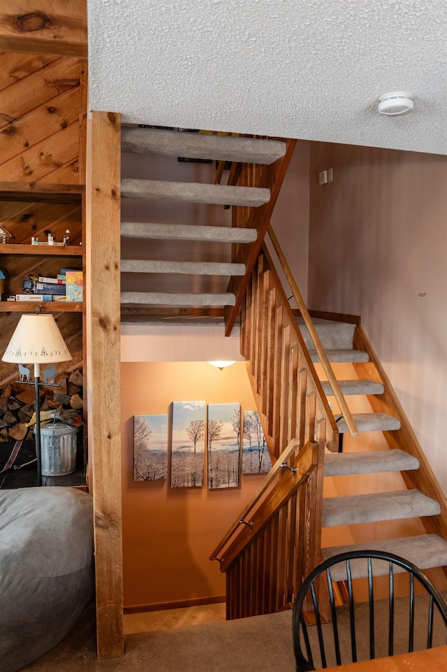 staircase featuring carpet floors and a textured ceiling