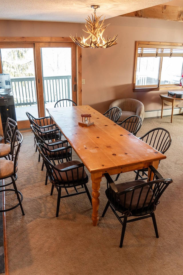 dining area featuring baseboard heating, plenty of natural light, an inviting chandelier, and carpet