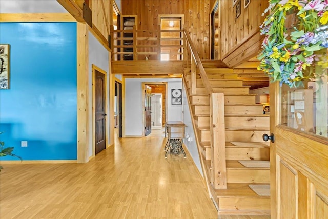 staircase featuring a towering ceiling and hardwood / wood-style floors