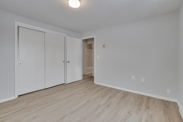 unfurnished bedroom featuring light wood-type flooring and a closet