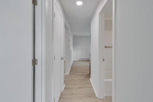 hall with a baseboard radiator and light hardwood / wood-style flooring