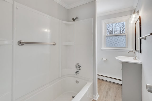 bathroom featuring washtub / shower combination, wood-type flooring, baseboard heating, vanity, and ornamental molding