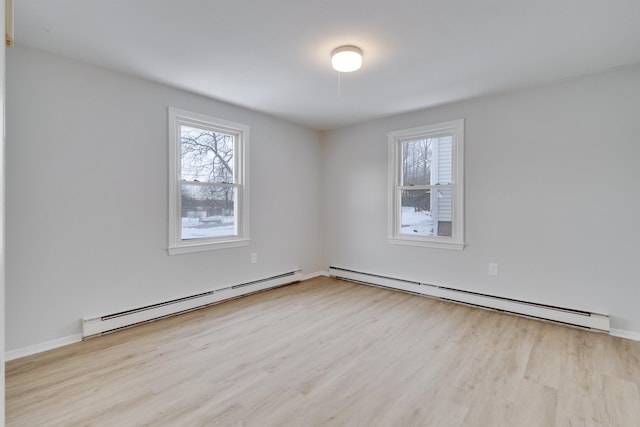 empty room with a baseboard heating unit and light hardwood / wood-style floors