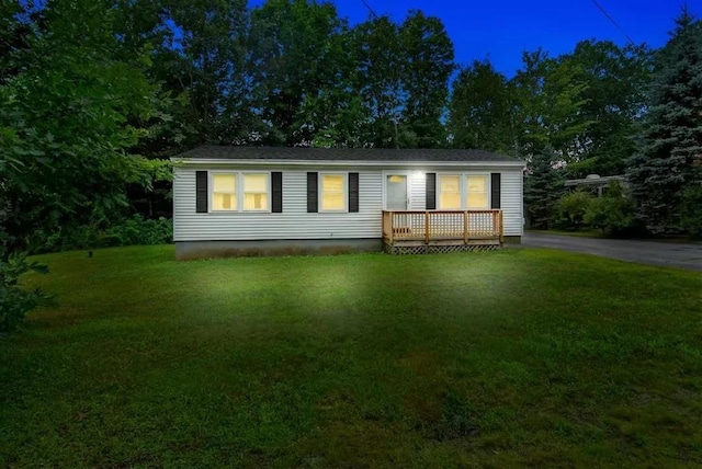 view of front of house featuring a wooden deck and a front yard