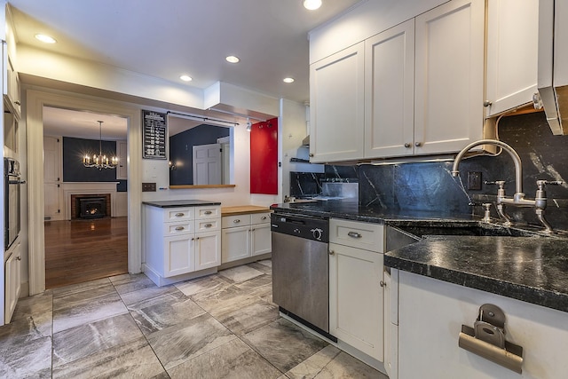 kitchen featuring tasteful backsplash, dishwasher, sink, and white cabinets