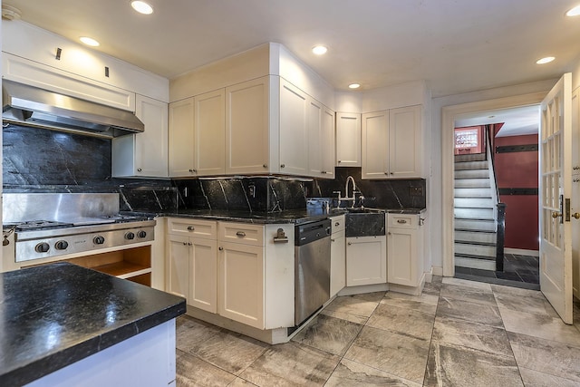 kitchen with white cabinetry, stainless steel appliances, wall chimney exhaust hood, and backsplash