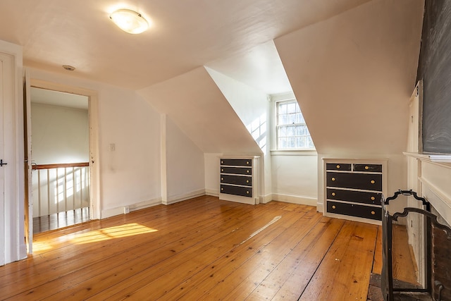 additional living space with vaulted ceiling and light wood-type flooring