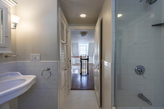 bathroom featuring tile walls, tile patterned flooring, and a shower with shower door