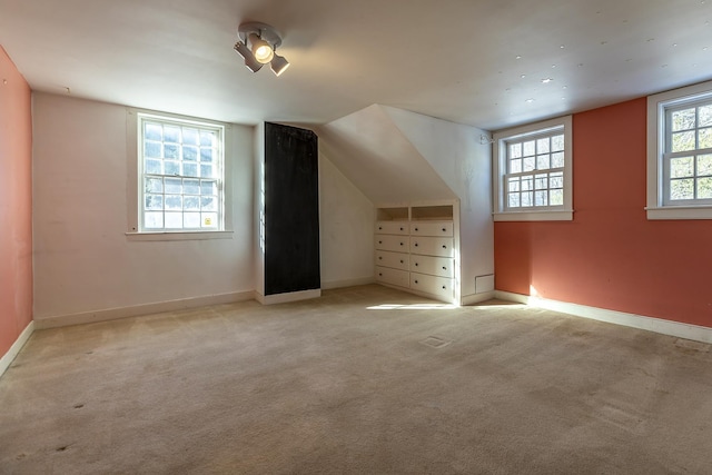 additional living space with lofted ceiling and light carpet