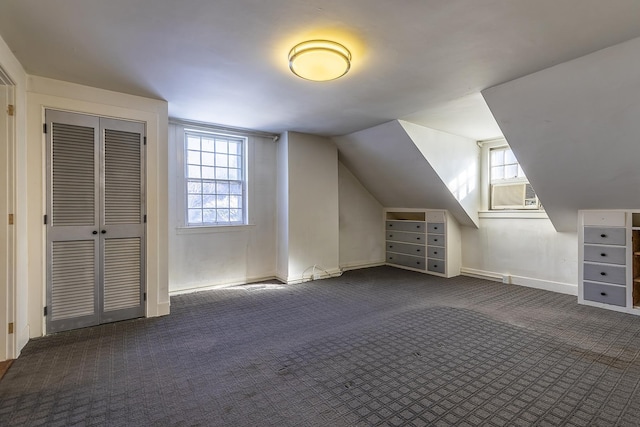 bonus room with vaulted ceiling and dark colored carpet