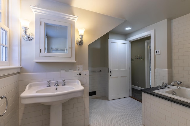 bathroom with tile patterned floors, a bathing tub, and tile walls