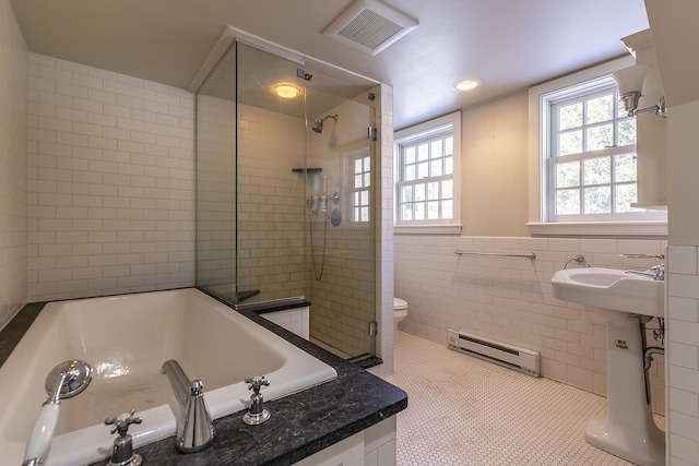 bathroom featuring toilet, separate shower and tub, tile walls, and a baseboard heating unit