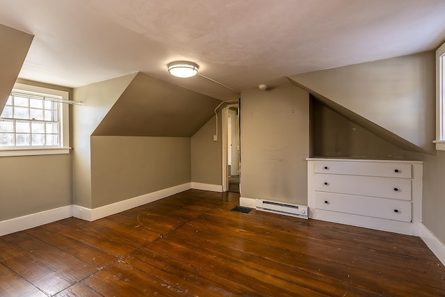 additional living space featuring baseboard heating, vaulted ceiling, and dark wood-type flooring