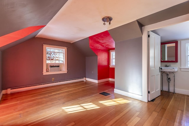 bonus room featuring lofted ceiling, a baseboard heating unit, hardwood / wood-style floors, and cooling unit