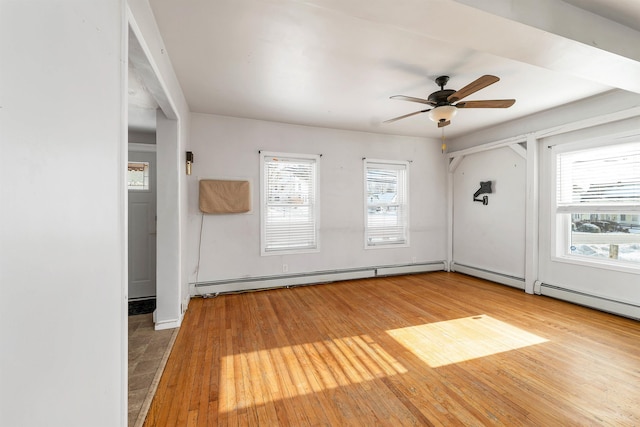 spare room featuring a baseboard radiator, plenty of natural light, and hardwood / wood-style floors