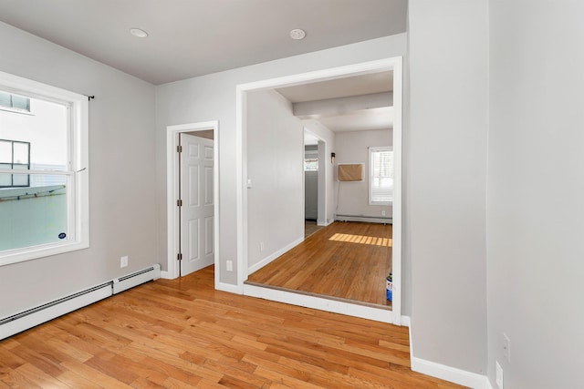 interior space featuring a baseboard heating unit and light hardwood / wood-style floors