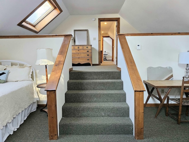 stairs with vaulted ceiling with skylight and carpet flooring