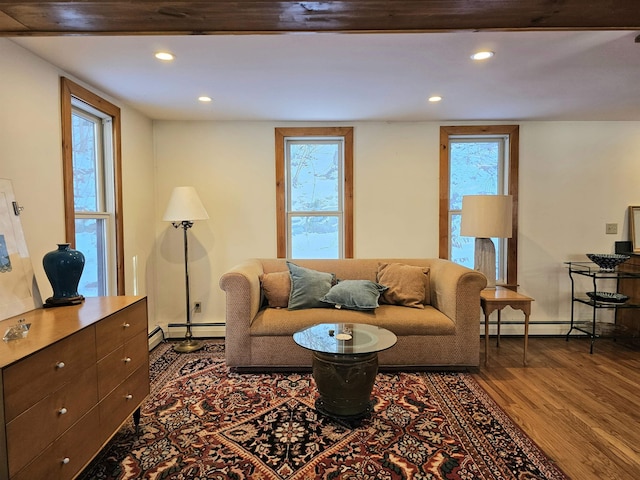 living room featuring a baseboard heating unit and hardwood / wood-style flooring