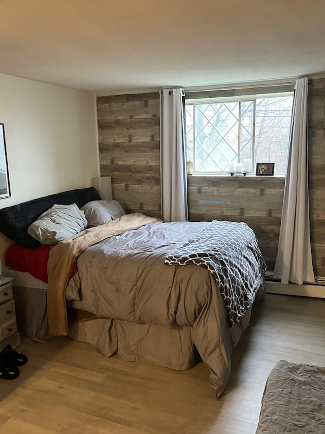 bedroom with a baseboard radiator and light hardwood / wood-style floors