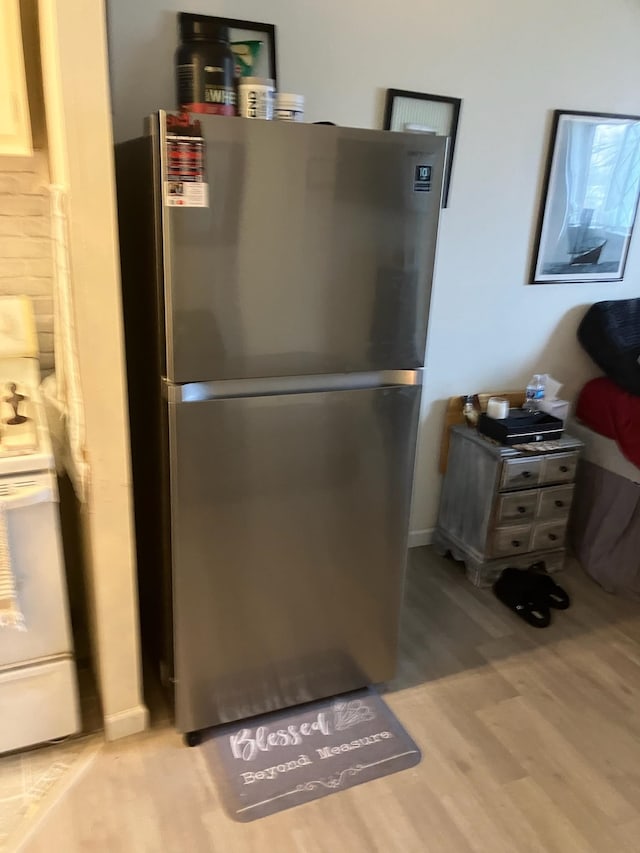 interior space with hardwood / wood-style flooring, stainless steel fridge, and range