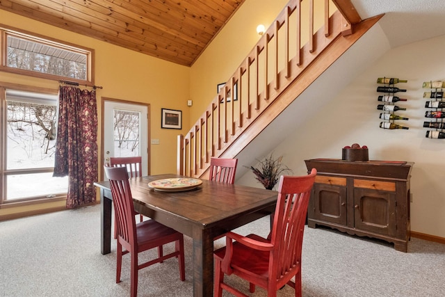 carpeted dining area featuring wooden ceiling and high vaulted ceiling