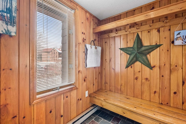 mudroom featuring wooden walls, a textured ceiling, and plenty of natural light