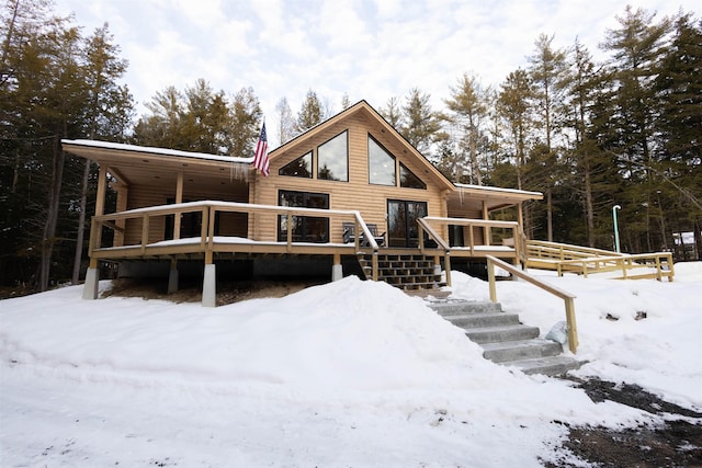 snow covered property with a deck