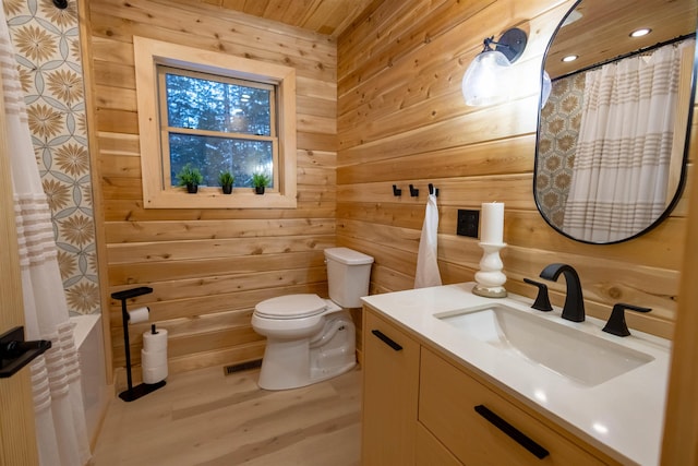 bathroom with vanity, hardwood / wood-style floors, toilet, and wood walls